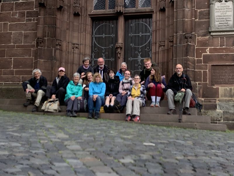 Gruppenbild der Pilgergruppe auf der Treppe vor einer Kirche sitzend.